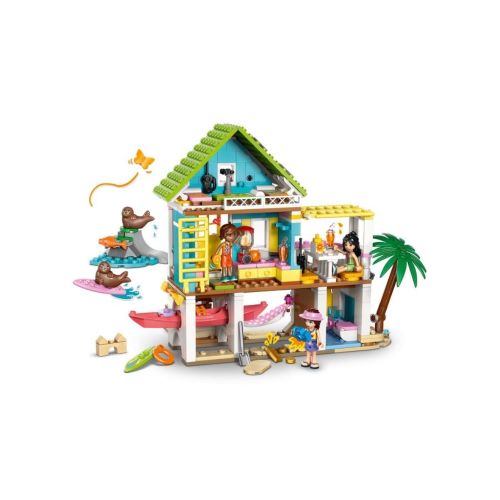 Vorderansicht des LEGO® Friends Strandhauses 42699 auf einer hellen Fläche mit einer Spielfigur im Kajak und zwei Robben auf einer kleinen Insel.