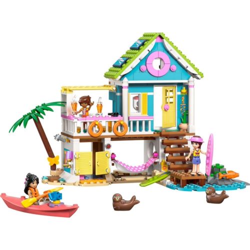 Das fertig aufgebaute LEGO® Friends Strandhaus 42699 mit geöffneter Rückseite, Rutsche, Windrad und Zubehör wie Kajak und Surfbrett.
